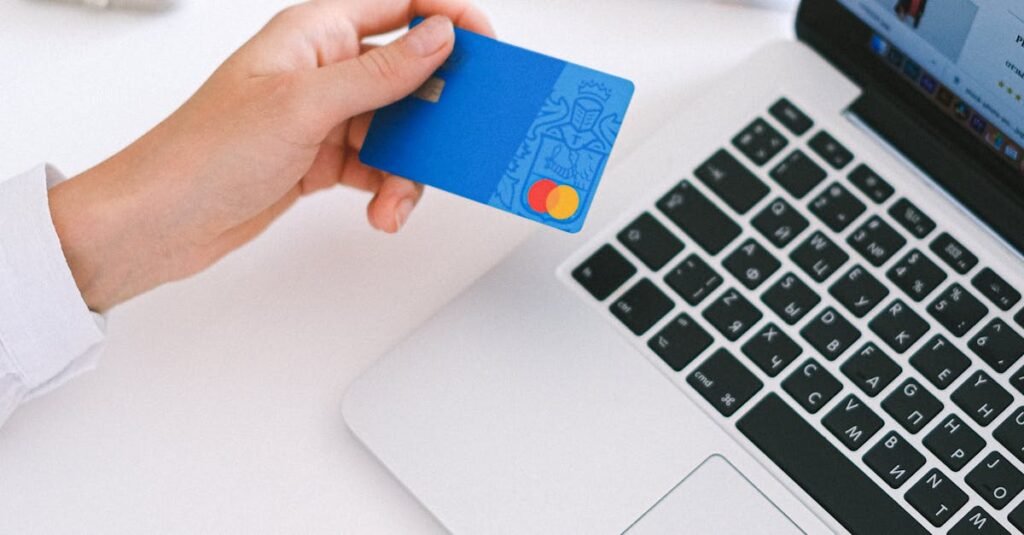Person making an online purchase with a credit card on a laptop, showcasing modern ecommerce technology.