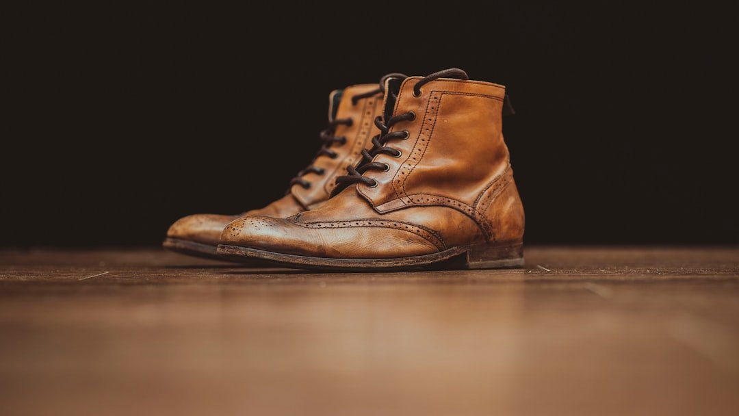 Brown leather boots on wooden surface - leather shoe care guide NZ How to Care for Leather Shoes & Boots NZ